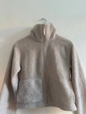 Teddyjacka - Säljer en fluffig beige teddyjacka i storlek xs från HM. Använd ett flertal gånger men i superfint skick. Perfekt för kyligare dagar 🌸