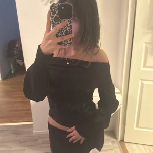 Svart offshoulder topp från Zara - Snygg svart offshoulder topp från Zara i en tight passform. Perfekt för en stilren look med långa ärmar och en asymmetrisk design. Tillverkad i ett mjukt material som sitter bekvämt på kroppen. 