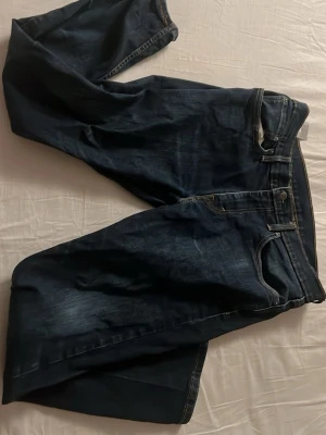Levi's 502 mörkblå jeans W32 L30 - Säljer ett par Levi's 502 jeans i mörkblå tvätt med klassiska fem fickor och snygga kontrastsömmar. Modellen har rak passform och är tillverkad i slitstarkt bomullsmaterial. Perfekt för dig som gillar tidlös denimstil.