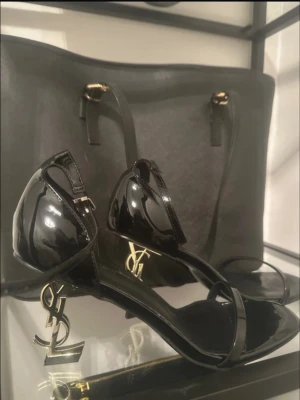 YSL klackar - YSL Opyum Sandals I Patent Leather. Skorna är äldre och har blivit några få gången använda, men är fortfarande i bra skick.  Anledningen till att jag säljer dem på är helt enkelt att jag är väldigt lång, och dessa klackar passar inte mig längre jag är inte i den eran av mitt liv längre 😅 Vill därför sälja dem vidare till någon som faktiskt kommer använda dem.  Pris kan diskuteras, hör av dig så kan vi förhandla.
