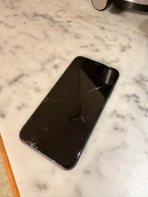 Svart iPhone 11 från Apple - Säljer en svart iPhone 11 som jag har liggandes för, repor och sprickor finns men fungerar som vanligt endå. 64gb, 87% batterihälsa 