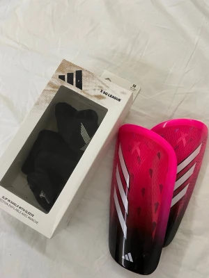 Adidas benskydd X SG League rosa - Säljer ett par Adidas X SG League benskydd använt en gång men dom passa inte.