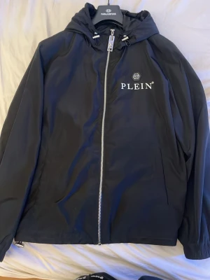 ÄKTA Svart vindjacka från Philipp Plein - Säljer nu min Phillipp plein jacka för att jag är sugen på nytt? Skick 10/10. Tar även byten digitalt kvitto finns också.  Nypris 11,000kr 