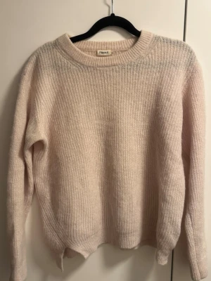 Ljusrosa stickad tröja Filippa K - Mysig ljusrosa stickad tröja från Filippa K med rund halsringning och ribbade muddar. Tröjan har en avslappnad passform och är tillverkad i ett mjukt, fluffigt material som känns lyxigt och skönt mot huden. 32% alpacka