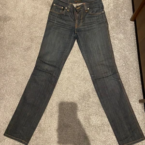 Mörkblå  Nudie Jeans - Skitsnygga nudie jeans med perfekt slitning och fade. W30 L34 