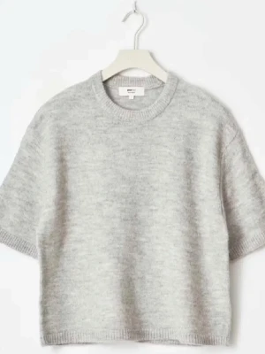 Ljusgrå croppad stickad topp - Supermjuk och croppad ljusgrå stickad topp med korta ärmar och rund hals. Perfekt till ett par höga jeans eller mjukisbyxor för en chill look. Enkel och stilren design utan mönster eller detaljer.