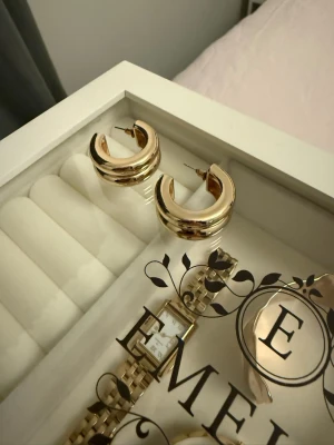 Guldiga hopps från Gina - Chunky hoops i guld från Gina