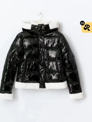 Svart glansig pufferjacka med fuskpäls - Snygg svart pufferjacka med glansig finish och vit fuskpäls på huva, ärmslut och nederkant. Jackan har dragkedja och stora fickor framtill. Perfekt för kalla dagar och ger en cool look. Storlek L men passar för mig som har vanligtvis storlek S💕