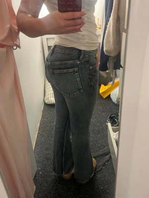 Grå bootcut jeans - Säljer ett par   jeans med bootcut passform och låg midja. De ser gråa ut på bilden är mer blå i verkligheten! Har klippt byxorna för att passa mig som är 160cm!