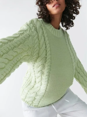 Ljusgrön kabelstickad tröja - Trendig ljusgrön stickad tröja med grova kabelstickade detaljer längs ärmar och sidor. Tröjan har rund halsringning, ribbade muddar och en relaxed fit. Perfekt för dig som vill ha en mysig men ändå snygg look.