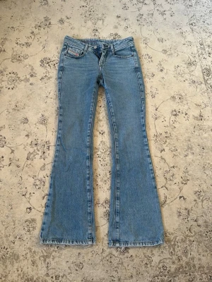 Blå bootcut jeans från Diesel  - Säljer ett par ljusblå bootcut jeans från Diesel med låg midja. Köpta i butiken för 2000kr. Storlek 24 längd 32. Väldigt bra skick. 