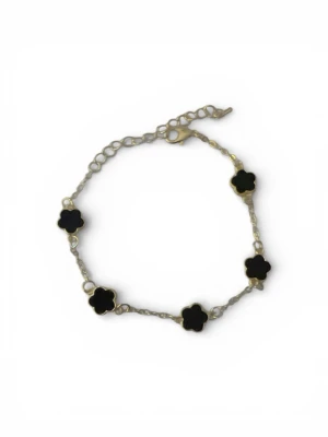 Guldarmband med svarta blommor - Stilrent armband i guldton med fem svarta blommor som dekoration. Kedjan är tunn och justerbar med ett klassiskt lås. Perfekt för dig som gillar en elegant och trendig accessoar med unik design.