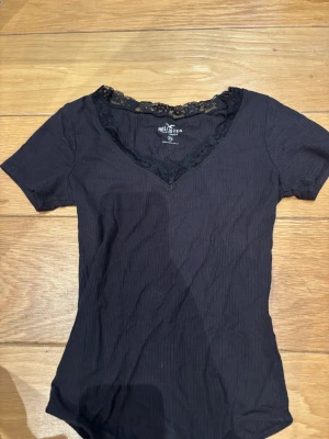 Hollister topp - Ribbad topp från Hollister med v-ringning och spetsdetaljer runt halsen. Den knäpps nertill💕