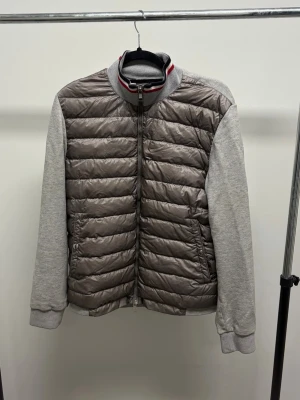 Moncler Cardigan - Grå cardigan jacka från Moncler. Lappen i nacken har lossnat på ena sidan annars riktigt fint skick. Storlek XL sitter som en medium/large.