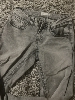 Grå flare jeans från gina tricot - Snygga grå flare jeans från Perfect Jeans med klassisk femficksdesign och silverfärgade knappar. Jeansen har en flare passform och är tillverkade i stretchigt jeanstyg för extra komfort. Perfekta för en trendig och avslappnad look.