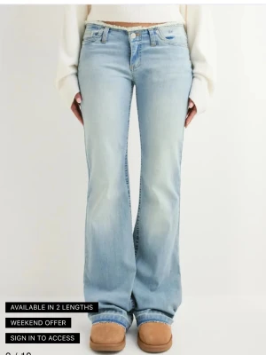 Ljusblå bootcut jeans med rå kant - Säljer ett par ljusblå bootcut jeans med rå, fransad midjekant och klassiska fem fickor. Jeansen har en lätt tvättad look och är tillverkade i stretchigt denim för skön passform. Perfekta för en avslappnad och trendig stil.