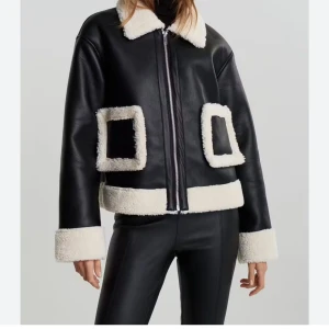 Svart teddyjacka från Gina Tricot XS - Säljer en svart teddyjacka från Gina Tricot i storlek XS. Jackan har vita teddy-detaljer på krage, ärmslut, fickor och nederkant. Den är i syntetmaterial med dragkedja framtill och har en boxig, lite oversized passform. Perfekt för kalla dagar.