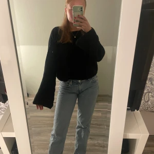 Svart stickad tröja från NA-KD - Svart stickad tröja från NA-KD i storlek XS. Tröjan har breda, långa ärmar och en lite croppad passform. Ribbstickad struktur som ger en snygg och trendig look. Perfekt att styla med jeans eller kjol för en chill vibe.