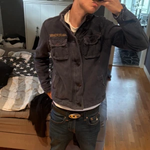 Mörkblå jacka från Abercrombie - Säljer en mörkblå jacka/tröja från Abercrombie med hög krage, går att vika ner. Snygga knappar på. Bra kondition. Endast lite svårt att stänga zipen men det går. Sitter åt tight