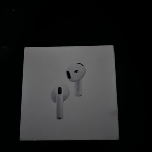 AirPods 4 - Apple AirPods 4 med aktiv brusreducering. Trådlösa hörlurar med laddningsetui, kompatibla med USB-C, Apple Watch och Qi-laddare. Produkten och förpackningen visar visst slitage men är i gott skick och fungerar som de ska.