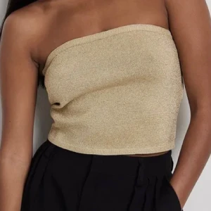 Glittrig tubtopp från NA-KD - Snygg guld glittrig tubtopp från NA-KD i bandeau-modell.  Köpt för 299kr aldrig använd, prislappen är kvar! 💞 