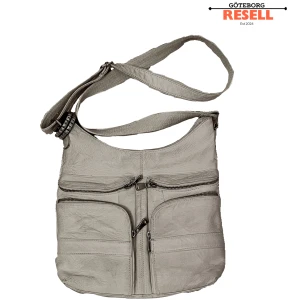 grunge väska med diy nit detaljer - Snygg cream väska med flera praktiska fack och dragkedjor framtill. Väskan har en bred, justerbar axelrem och en stilren design som passar perfekt till vardags. Nit detalj kommer med, ej avtagbar. Skick: 5/10