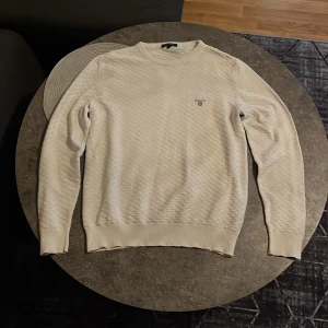 GANT Stickad Tröja - Säljer en stilren vit premium modell stickad tröja från GANT i storlek S. Originalpris: 1600 kr