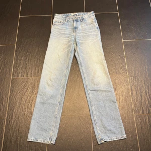 Ljusblå raka jeans från Pull&Bear - Säljer ett par ljusblå jeans från Pull&Bear i klassisk rak modell. Jeansen har fem fickor, normal passform och stängs med knapp och dragkedja. Perfekta för en chill och stilren look. Materialet är klassisk jeansbomull.