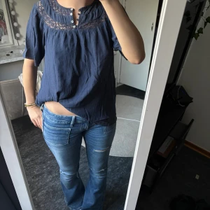 Mörkblå blus med spets från KappAhl - Supersöt mörkblå blus från KappAhl med korta ärmar och dekorativ spets upptill.