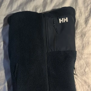 Mörkblå teddyjacka från Helly Hansen - Säljer en mörkblå teddyjacka från Helly Hansen, den passar bra för dig som är runt 165 till 168 cm