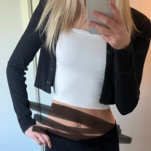 Svart kofta - Säljer en svart kofta med enkel och stilren design. Koftan är lite kortare och har små knappar. Perfekt att ha till ett par jeans eller en kjol.