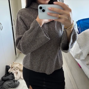 Brun stickad polotröja Stockh LM Studio - Mysig brun stickad polotröja från Stockh LM Studio i storlek XS. Tröjan har en lös passform, breda ärmar och ribbad polokrage. Perfekt för kyliga dagar och enkel att styla med både jeans och kjol.