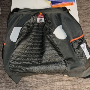 Militärgrön  Parajumpers pufferjacka M - Säljer en militärgrön pufferst från Parajumpers i storlek M. Jackan har quiltad insida, dragkedja och coola orange detaljer. Materialet är polyester.
