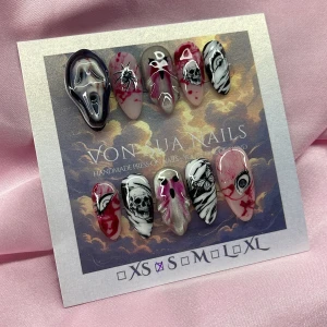 BloodyHorror(S);Medium Almond - Set med handgjorda press-on naglar i storlek S: 15 mm, 11,5 mm, 12 mm, 11 mm, 9 mm, dekorerade med skräckinspirerade motiv som dödskallar, blodstänk, ögon, spindlar och svartvita detaljer. Färgerna är svart, vitt, rött och silver med glansig finish. 