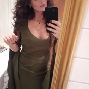 Grön långklänning med öppen rygg - Säljer en elegant grön långklänning från asos med dramatisk capeärm och djup urringning. Klänningen har en snygg öppen rygg med knappar i nacken. Använd en gång på förlovnings fest, så i extremt gott skick.  Jag är storlek 36, och denna 38 satt bra med lite utrymme kvar, inte supertight utan lite lätt löst. 