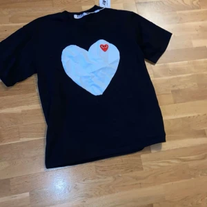 Svart CDG T shirt - Säljer min svarta CDG T shirt. Den är i storlek M, kan även passa L. Den är oanvänd och meet ups fungerar, endast i Stockholm.