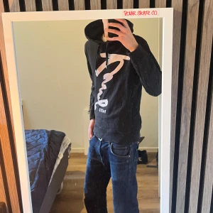 Svart hoodie kenzo - Svart hoodie kenzo. med stor vit grafisk print och texten 'Paris' framtill. Tröjan har huva med snörning och långa ärmar. Perfekt för dig som gillar streetwear och vill ha en skön och snygg look.