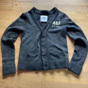 Mörkgrå ullkofta Abercrombie & Fitch - Säljer den här tjocka koftan för den sitter lite tajt på mig, perfekt inför det ruggiga höst vädret🍁🍂. Den är i storlek M men passar S-M, rättså tajt passform alltså. Tröjan har några år på nacken men är helt fri från defekter, noppror och den är givetvis nytvättad. Skriv gärna vid frågor eller för fler bilder(: