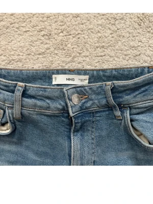Blå bootcut jeans från MNG - Low waist jeans från Mango i storlek 34, säljer då de är för små:)