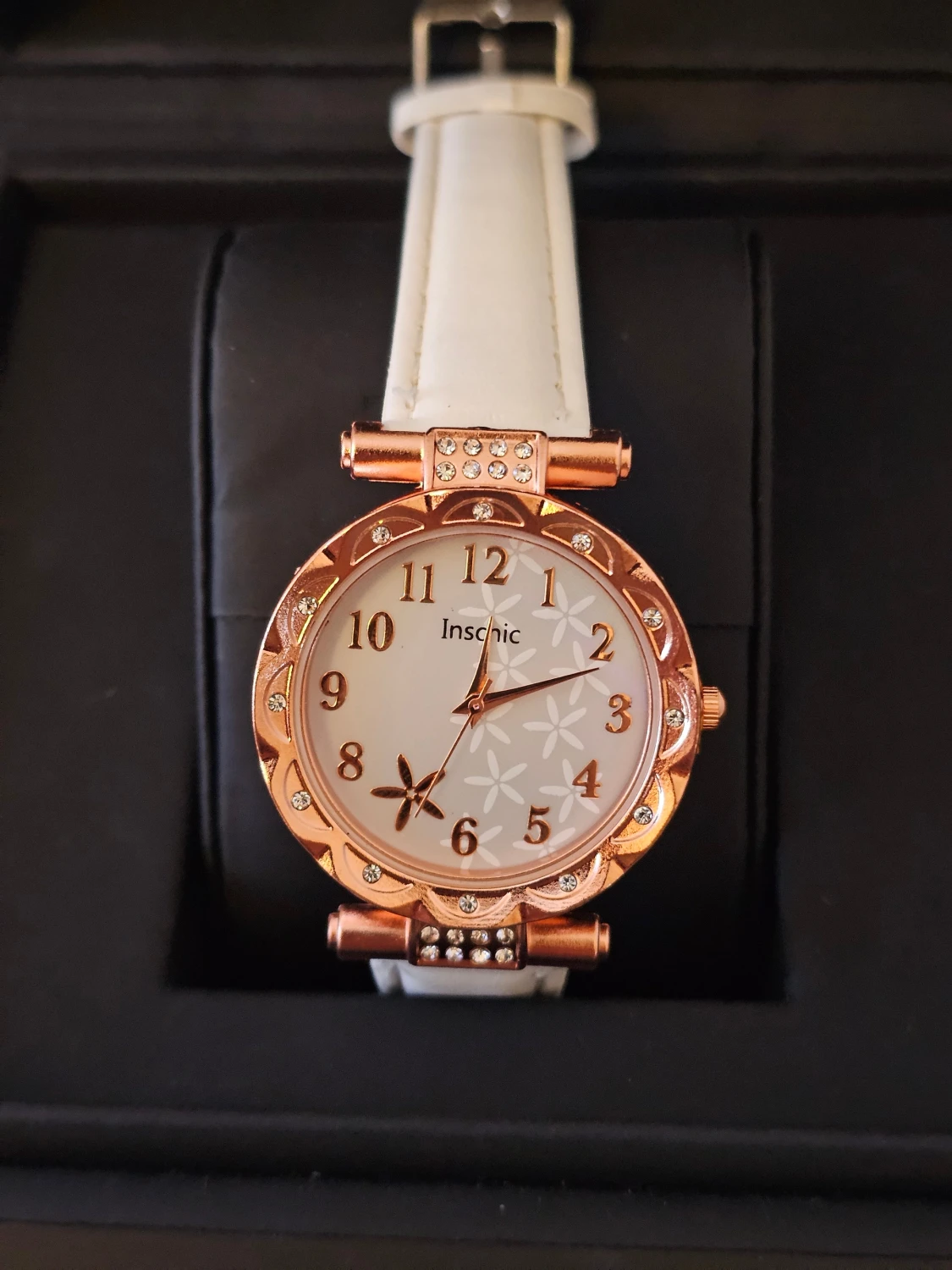 Vit klocka med roséguld och blommor