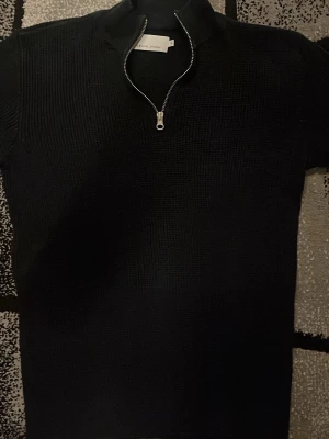 Svart/Mörk blå stickad Halfzip Casual Friday - Svart/Mörkblå stickad Half-Zip från Casual Friday i storlek S. Tröjan har en half zip-dragkedja framtill och ribbad struktur som ger en cool vibe. Långärmad modell