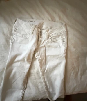 Vita pepe jeans med väldigt låg midja - Snygga vita jeans från pepe med låg midja och klassisk femficksdesign. Modellen har bootcut men ändå ganska raka ben och dubbla knappar i midjan. Materialet är mjukt och stretchigt jeans, perfekt för en clean och fräsch look. Köpta för 850 men säljer för 450💕