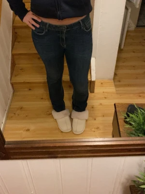 Mörkblå jeans med straight fit - Snygga mörkblå jeans med klassisk straight fit och normal passform. Byxorna har fyra fickor och midwaist, vilket ger en bekväm och stilren look. Perfekta för dig som gillar enkel och tidlös denimstil.