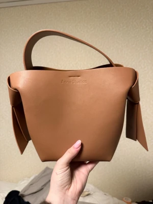  Acne Studios väska - Säljer en väldigt fin väska, har inget tecken på användning! Köpt på Vinted utan kvitto så kan inte garantera äkthet därav säljes till en billigare pris än andra likande acne väskor!😍kommer även med ett långt band om man vill ha väskan runt kroppen!