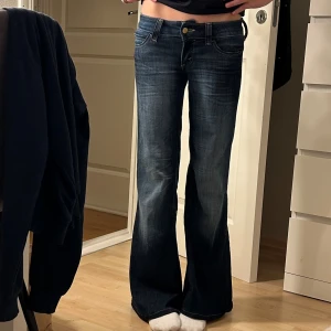 Mörkblå bootcut jeans  - Snygga mörkblå jeans från cheep monday med bootcut passform och klassisk femficksdesign. Jeansen har låg midja, slitningar framtill och bak, samt en cool patch på bakfickan. 💞💞☺️är ca 165 cm