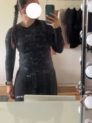 Svart träningströja Kari Traa mönstrad - Svart långärmad träningströja från Kari Traa med diskret mönster i grått. Tight passform och stretchigt material som andas, perfekt för träning. Snygg detalj med logga nertill och silikonband i nederkant för att hålla tröjan på plats. Står ingen storlek men skulle uppsatta xs/s. Allt ska bort så accepterar alla rimliga bud. 