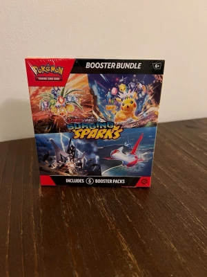 Pokémon TCG – Scarlet & Violet: Surging Sparks Booster Bundle - Säljer en helt ny och oöppnad Booster Bundle från Scarlet & Violet – Surging Sparks. Perfekt för dig som vill öppna fler paket utan att köpa en hel box! Innehåll:  6 boosterpack från Surging Sparks-expansionen Varje booster innehåller 10 kort + 1 energikort + 1 kodkort till Pokémon TCG Live Perfekt för att utöka samlingen eller jaga nya EX-, Tera- och ACE SPEC-kort. Fabriksförseglad och i toppskick. 