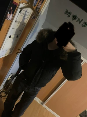 Superdry Everest Puffer Jacka - Säljer en svart pufferjacka från Superdry med stor huva och fuskpäls. Jackan har ribbade muddar, dragkedja och knappar framtill samt två stora fickor. Perfekt för kalla dagar och riktigt snygg till jeans.