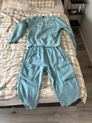 Nike Air ljusblå cargopants - Säljer ett par ljusblå cargopants från Nike Air med elastisk midja och stora fickor på sidorna. Byxorna har en loose passform och är gjorda i mjukt bomullsmaterial. Snygg logga på ena benet och vita detaljer längs sidorna. Perfekt för chill och streetwear. Bykorms storlek M och Tjörn storlek S JAG FRAKTAR INTE MÖTS BARA UPP I VÄSTRA GÖTALAND