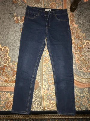 Mörkblå jeans från Silvia, storlek 27 - Snygga mörkblå jeans från Silvia i klassisk femficksmodell. Jeansen har raka ben, normal passform och är tillverkade i ett mjukt denimtyg med kontrastsömmar. Perfekta för dig som gillar en enkel och stilren look.